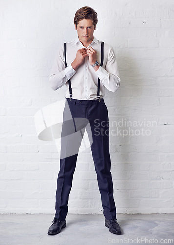 Image of Man, portrait and fashion with getting ready, confidence and suit with trendy and stylish clothes. Hipster, male person and wall with event, classic and fancy suspenders with dressing formal