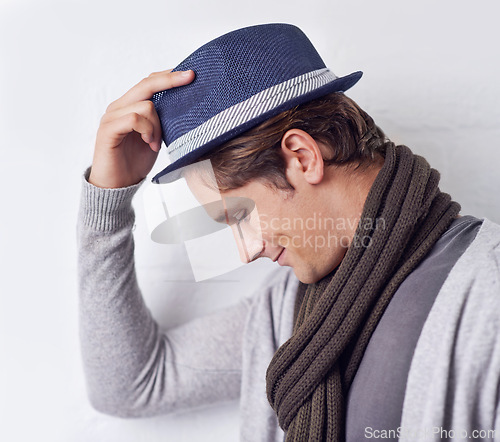 Image of Man, fashion and hat with confidence for style with wall background as hipster with scarf, clothes or relax. Male person, model and hand with smile in Canada for trendy headwear, cool or happiness