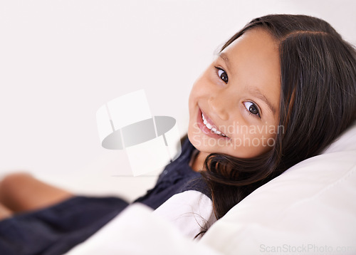 Image of Smile, relax and portrait of child on sofa for playful, fun and resting on weekend in living room. Happy, childhood and face of young girl alone on couch for comfortable, playing and lying in home