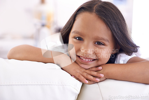 Image of Happy, relax and portrait of kid on sofa for playful, fun and resting on weekend in living room. Smile, childhood and face of young girl alone on couch for playing, comfortable and free time in home