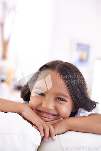 Image of Playful, relax and portrait of child on sofa for lying, fun and resting on weekend in living room. Smile, home and face of young girl alone on couch for happiness, comfort and childhood in Brazil