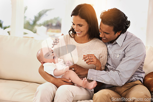 Image of Happy family, baby and hug on sofa for bonding, support or love together in relax at home. Father and mother holding little child, kid or newborn toddler on living room couch with smile at house