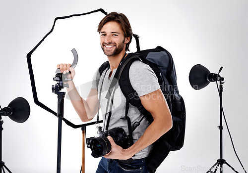 Image of Photographer, backpack and happy with camera in studio for career, behind the scenes and equipment. Photography, person or smile with lighting, confidence and shooting gear for photoshoot or passion