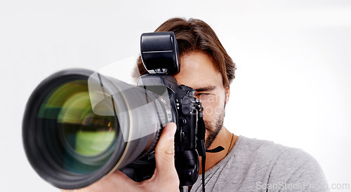 Image of Man, camera lens and photographer with technology in studio, press or media for news on white background. Photography, photo journalist and creative with paparazzi, equipment and closeup in studio
