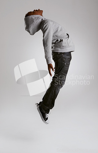 Image of Teen, fashion and jump with energy in studio with kid in streetwear hoodie on grey background. African, child and cool boy in the air with casual style, clothes and comfortable outfit in mockup