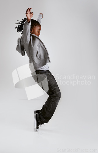 Image of Kid, fashion and dance with energy in studio with hoodie in streetwear on grey background. African, child and cool teenager or dancer with casual style, clothes and balance on shoes in mockup