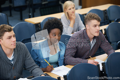 Image of College, writing and students learning with notes in class, auditorium or lecture hall for education. University, classroom or people in campus for knowledge or studying a course in academy or school