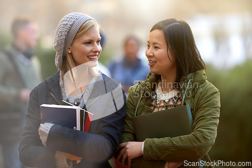 Image of School, books and conversation with woman friends outdoor on campus together for learning or development. College, education or university with young student and best friend talking at recess break