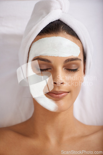 Image of Happy woman, relax and face mask at spa for skincare, beauty or makeup cosmetics at hotel or resort. Calm female person or model with smile in satisfaction for facial treatment, zen or anti aging