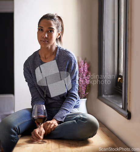 Image of Wine, glass and portrait of woman in home to drink and relax in kitchen at the window. Serious, person or alcohol on counter in living room of house for calm weekend, holiday or vacation in apartment