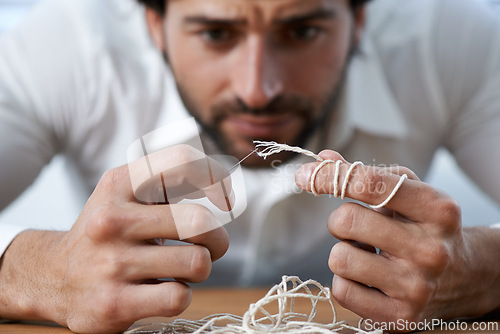 Image of String, thread and man with eye of needle for stitching, sewing and needlework in fashion industry. Struggle, concentration and hands of person with tools for material, textile and tailor business