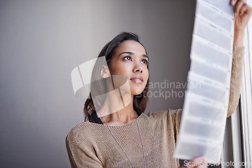 Image of Photography, woman and photographer with negatives for photo by window with filmstrip, project and freelancer. Artist, creative and artistic hobby, art and portfolio with examine, looking and study