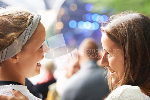 Image of Happy, friends and women at music festival, concert or party for social life, excited and talking of rave or techno. People, audience or crowd from back at a carnival, event and bokeh on a stage