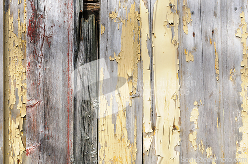 Image of Worn and weathered wooden boards with peeling yellow paint