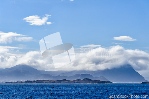 Image of Majestic coastal landscape with cloud-covered mountains and sere