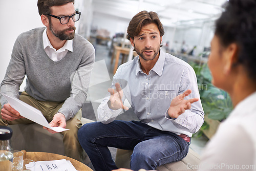 Image of Businessman, documents and meeting with team in discussion for planning, brainstorming or finance at office. Young group of employees with paperwork in budget, strategy or financial plan at workplace