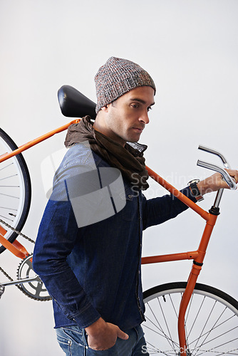 Image of Bicycle, walking and man in building carrying bike for healthy and eco friendly transportation for travel. White background, thinking and cyclist with hipster and journey for carbon neutral commute