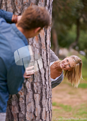 Image of Couple, park and smile with playing for hide and seek, love and happiness in outdoor setting in Los Angeles. Relationship, romance and fun day in forest for lifestyle, wellness and relax for bonding