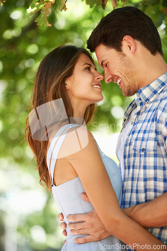 Image of Couple, smile and happy in nature for love, bonding and connection with trees in sunshine in Canada. Man, woman and date with romantic embrace for admiration, care and hug in park on Valentines Day