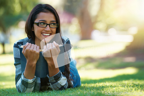 Image of Happy woman, student and relax with book in nature for literature, studying or story on green grass. Young nerd, geek or female person with smile and glasses for chapter, learning or outdoor reading