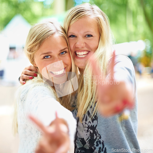 Image of Peace hands, portrait and women friends hug in a park with freedom, fun and bonding in nature together. V sign, face and people embrace in a forest for travel, vacation or weekend reunion outdoor