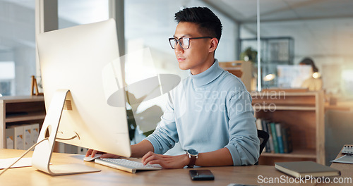 Image of Asian man at computer, glasses and ideas, thinking and reading email, web review or article at digital agency. Research, reflection and businessman at tech startup networking on business website.