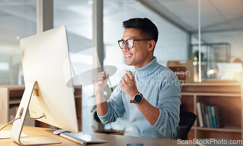 Image of Happy asian man, fist pump and celebration for winning, promotion or bonus on computer at office. Excited male person or employee wow in achievement, target or good news for victory, success or deal