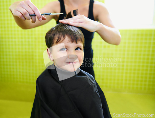 Image of Child, boy and hairdresser with haircut at salon for grooming, hairstyle and grimace with scissors and comb. Barber, person and kid for hair treatment, haircare and hairstyling with cutting and happy