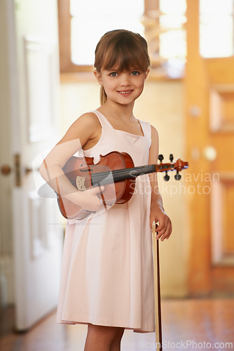 Image of Violin, girl and portrait of happy kid in home for learning, practice and music education. Art, fiddle and student with bow for talent, creative or hobby with acoustic string instrument in Canada
