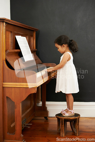 Image of Piano, stool and kid in home for learning, practice and classical education with musical notes. Training, melody and student with talent, creative or hobby with instrument, child development or skill