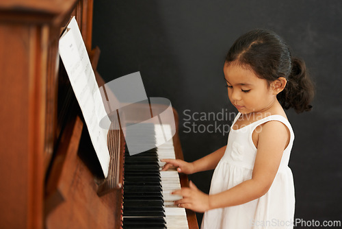 Image of Piano, girl and kid in home for learning, practice and classical education with musical notes. Training, melody and student with talent, creative or hobby with instrument, child development or skill