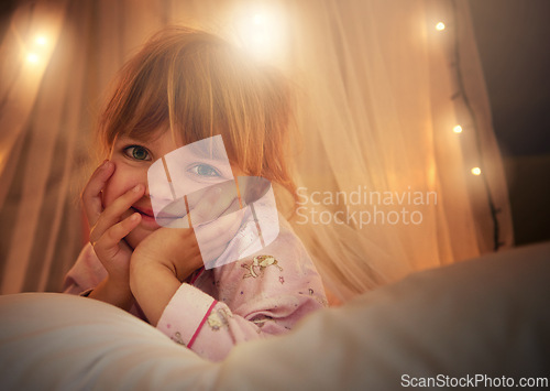 Image of Bed, lights and portrait of child at night for resting, relaxing and dreaming in home. Happy, smile and face of young girl with fairy light decoration in bedroom for fantasy, magic and childhood