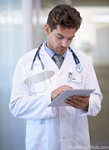 Image of Research, tablet and doctor in hospital for medical information on the internet for diagnosis. Reading, professional and male healthcare worker with telehealth on digital technology in clinic.