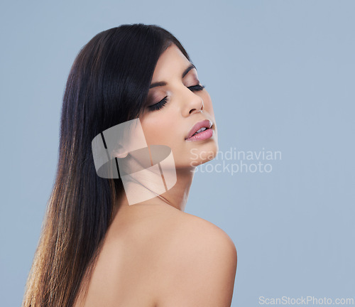 Image of Health, hair care and woman with cosmetics in studio for beauty, wellness and salon treatment. Confident, makeup and female person with facial and hairstyle routine by blue background with mockup.