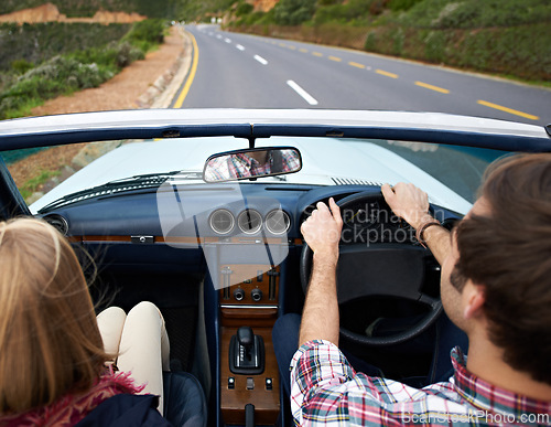 Image of Couple, driving and convertible steering wheel on road from behind on mountain for vacation, adventure or holiday. Man, woman and transportation in California for travel destination, relax or nature