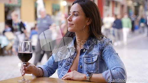 Image of Woman Enjoying Red Wine at Outdoor Cafe in Spain