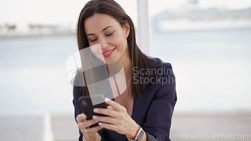 Image of Businesswoman Using Smartphone Near the Ocean