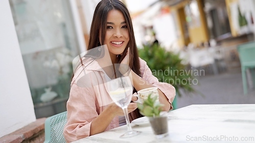 Image of Happy Woman Enjoying a Drink at an Outdoor Cafe