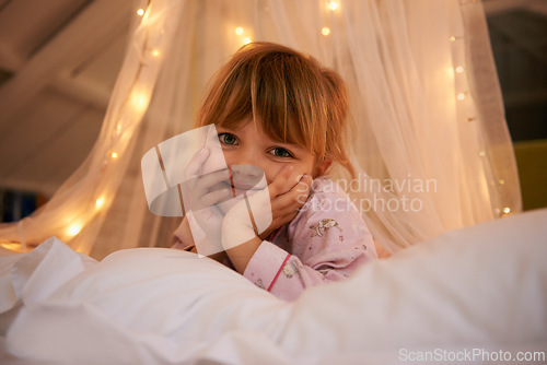 Image of Bedroom, lights and portrait of child at night for resting, relaxing and dreaming in home. Happy, smile and face of young girl with fairy light decoration on bed for fantasy, magic and childhood