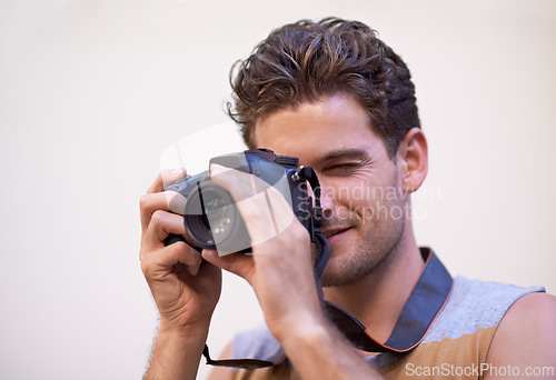 Image of Man, camera and photographer in studio for shooting, digital lens and tech for image or picture. Male person, hobby and equipment for photo on white background, production and capture for memories