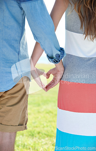 Image of Love, summer and heart hands with couple outdoor in garden, park or yard together for date from back. Emoji, peace or trust with man and woman in nature or environment for bonding and affection