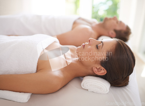 Image of Couple, relax and together in luxury spa for treatment on holiday or vacation with wellness. Beauty, care and calm people on table in hotel, salon or resort for skincare or cosmetics on break