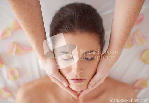 Image of Hands, above and massage face of woman at spa to relax, peace and calm for aromatherapy with organic flowers. Top view, therapy and person at salon for facial treatment, skincare or beauty for health