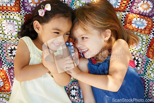 Image of Happy, nature and girl kids on blanket playing together in outdoor park or garden on vacation. Smile, bonding and high angle of young children friends relaxing in field on holiday or weekend.