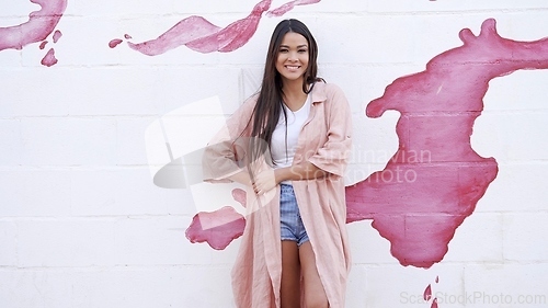 Image of Stylish Woman Standing Against a Pink Paint Splash Wall