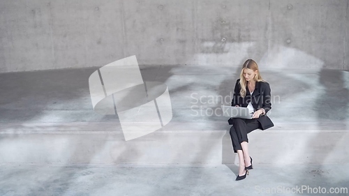 Image of Professional Woman Working on Laptop in Minimalistic Setting