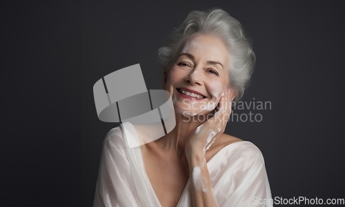 Image of Elderly woman applies facial cream, gracefully embracing a skincare routine