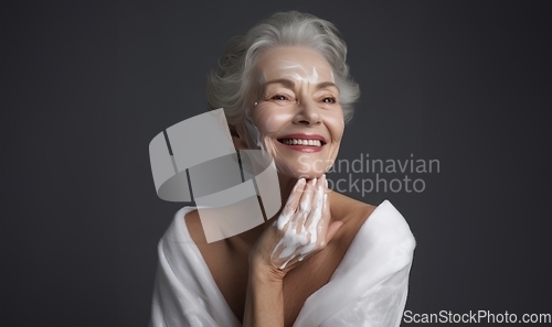 Image of Elderly woman applies facial cream, gracefully embracing a skincare routine