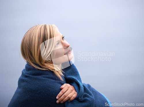 Image of Closeup, woman and outdoor with blanket for thinking with smile, wellness and contemplate for leisure. Holiday, reflect with memories in nature for happiness, relax and healthy mindset with vacation