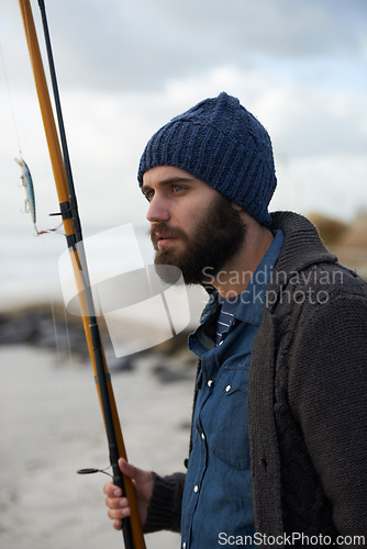 Image of Thinking, fishing and man at a beach for water hobby, recreation or stress relief in nature. Rod, waiting and male fisherman at the ocean for travel, journey or collecting fish adventure in Cape Town